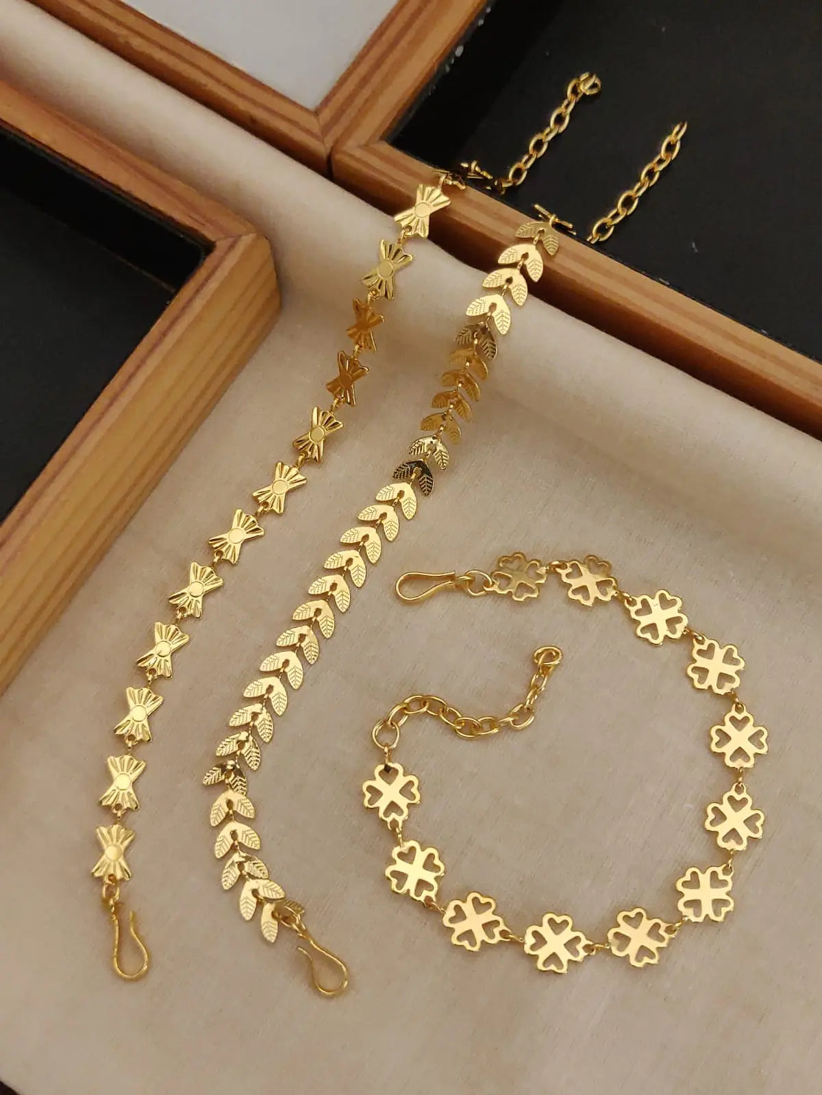 Gold floral chain necklace on a wooden stand