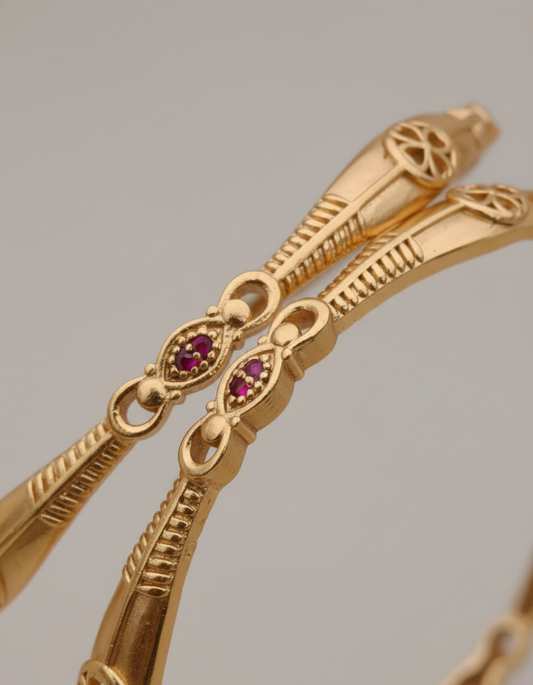 Gold bracelet with gemstones on a gray background