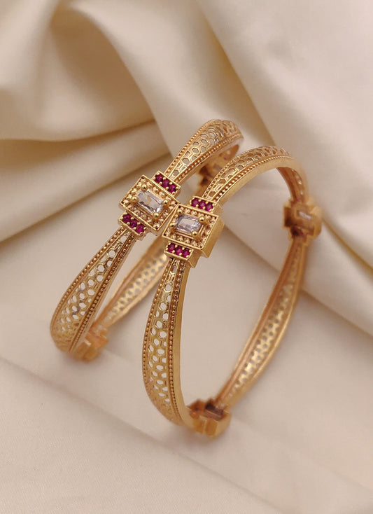 Gold Bangle with gemstones on a beige fabric background