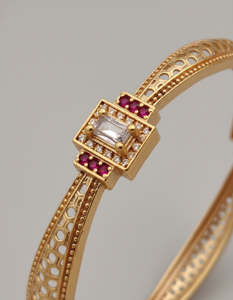 Gold bracelet with gemstones on a gray background