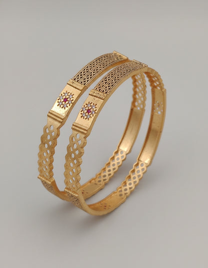 Gold Bangle with intricate design on a gray background