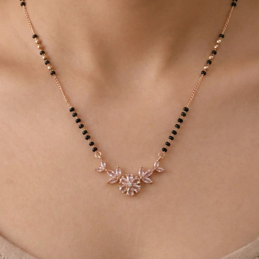 Necklace with black beads and floral pendant on a person's neck