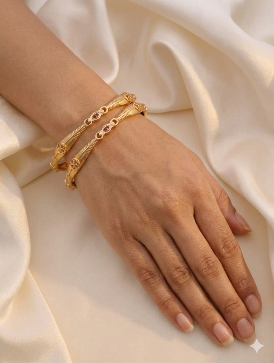 Hand wearing gold bangle on a beige fabric background