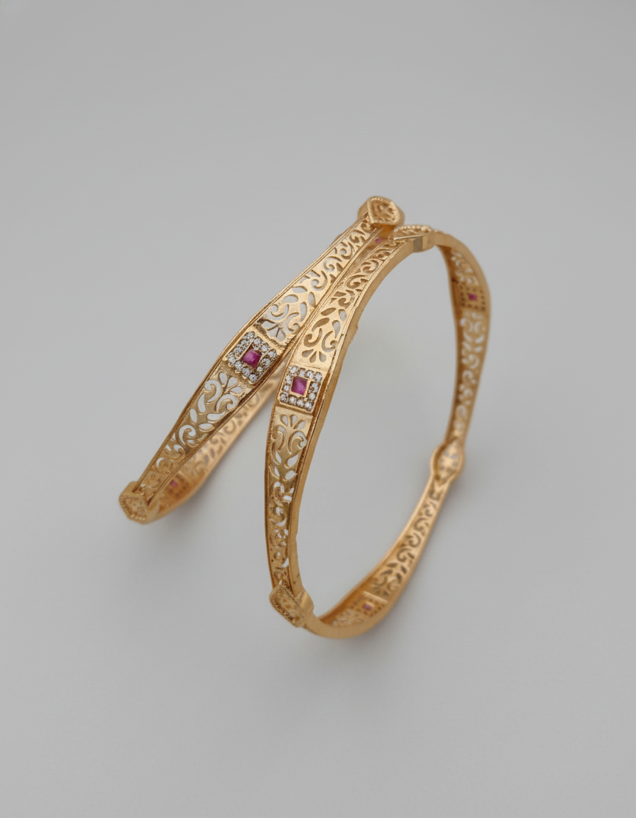 Gold bracelet with intricate designs and embedded gemstones on a gray background