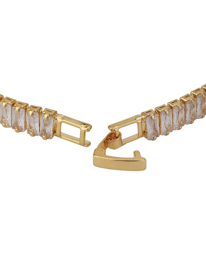 Gold bracelet with clear gemstones on a white background