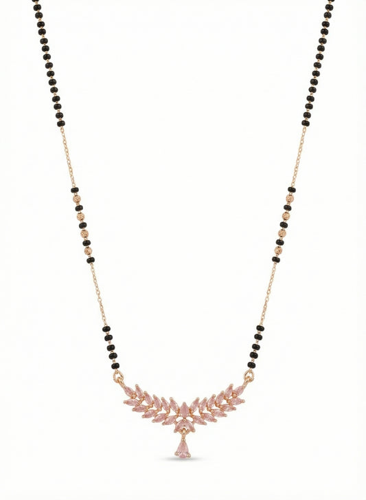 Necklace with black and gold beads and a pink leaf-like pendant on a white background