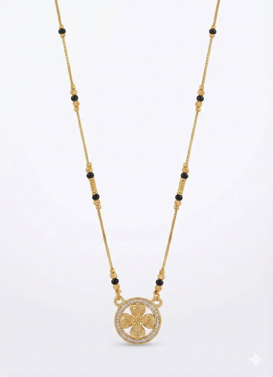 Gold necklace with black beads and a circular pendant on a white background