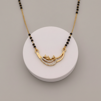 Gold necklace with black beads on a white round base